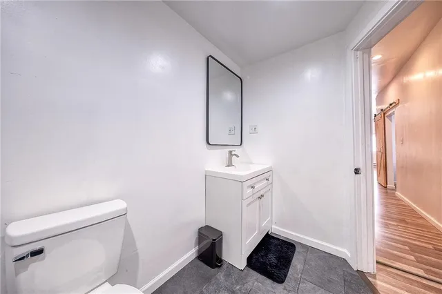 a bathroom with a toilet a sink and mirror