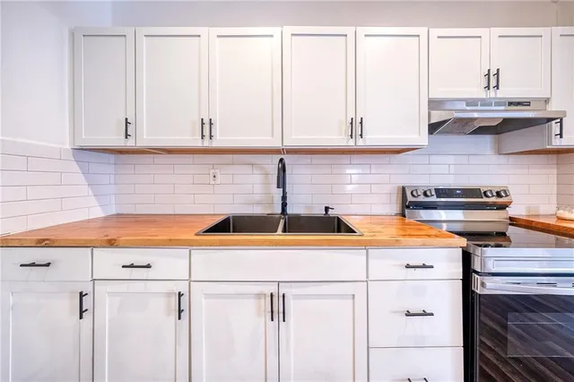 a kitchen with stainless steel appliances granite countertop a sink and a white cabinets