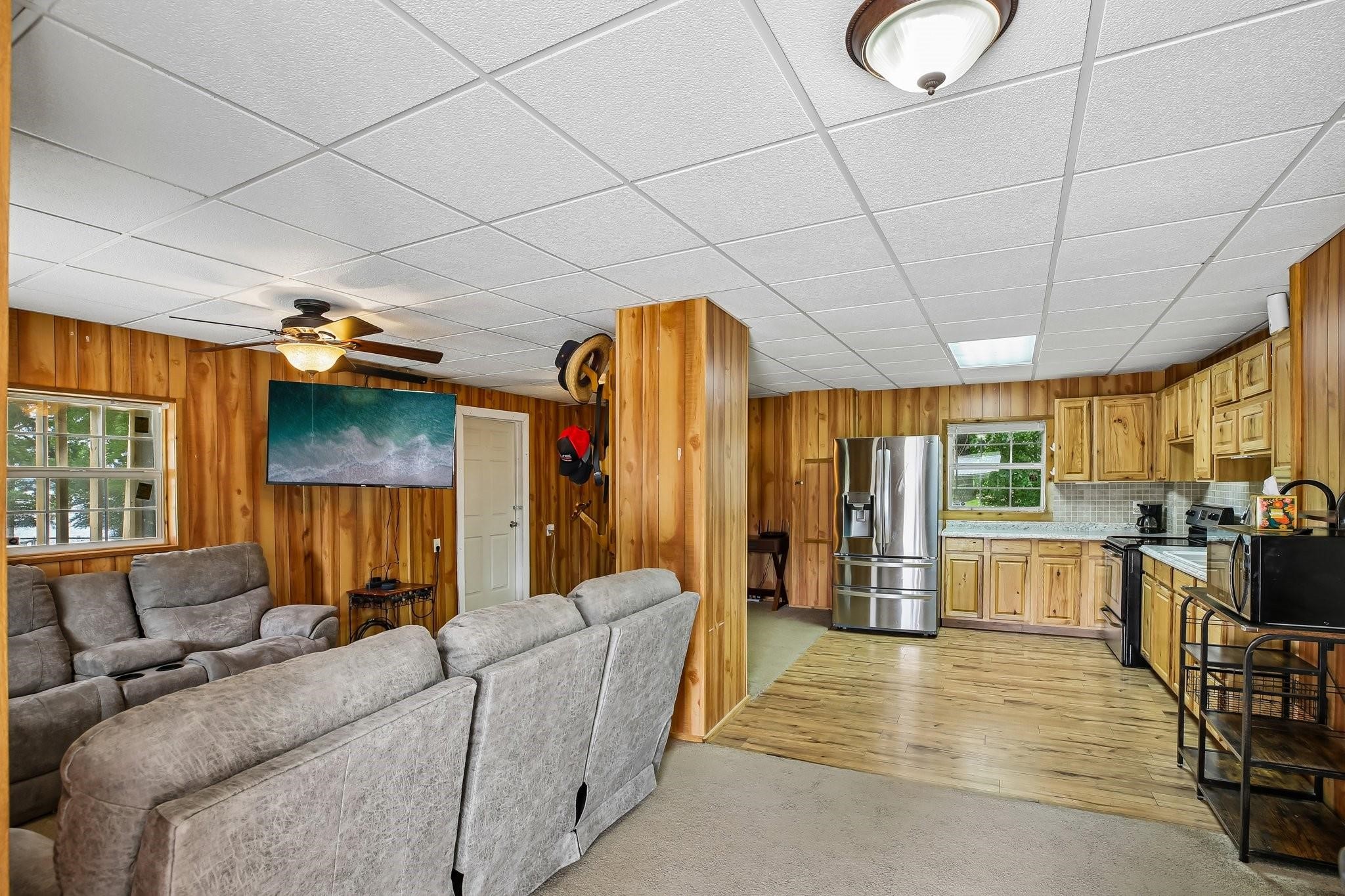 164 Frank Road Trinity, TX 75862 - Photo 14 of 20 14. This open-concept living and kitchen area serves as the heart of the home, radiating rustic charm with high-quality wood paneling throughout. The seamless flow between the functional kitchen and the cozy living space makes it an ideal layout for comfortable daily living and effortless entertaining.