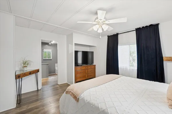 a bedroom with a bed and a flat screen tv