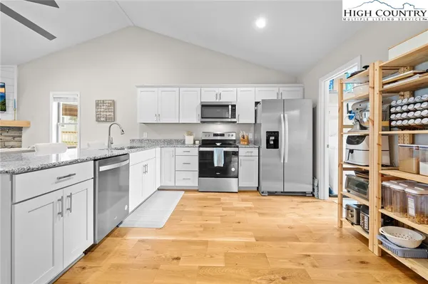 a large kitchen with stainless steel appliances granite countertop a stove a sink and a refrigerator