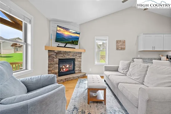 a living room with furniture a flat screen tv and a fireplace