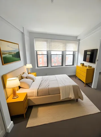 a bedroom with a bed couch and window