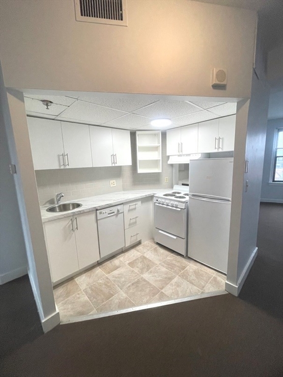 475 Commonwealth Avenue, Unit 606 Boston, MA 02215 - Photo 8 of 14 a kitchen with white cabinets and white appliances