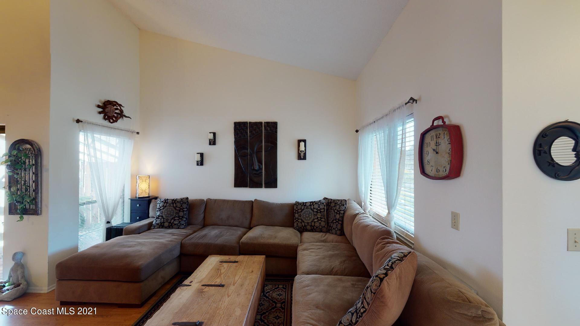 2210 Golf Isle Drive, Unit 906 Melbourne, FL 32935 - Photo 18 of 74 a living room with furniture a mirror and wall paintings