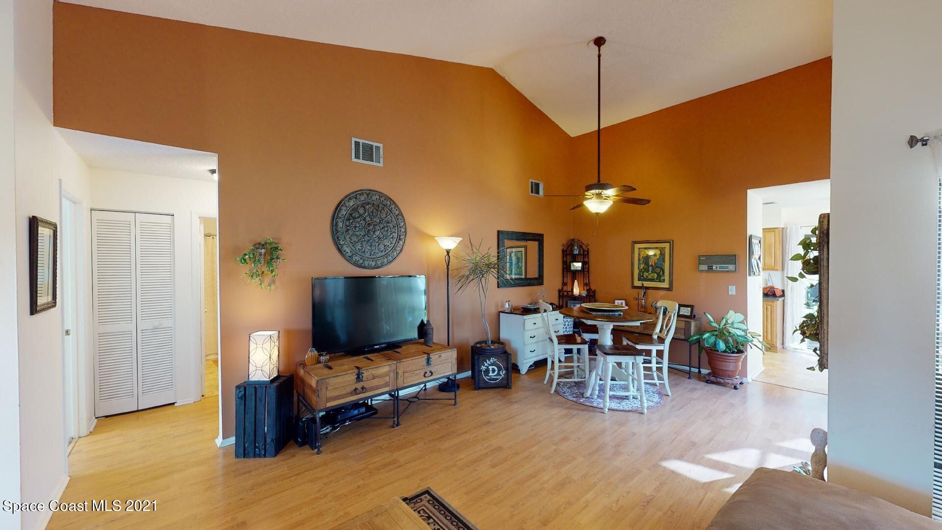 2210 Golf Isle Drive, Unit 906 Melbourne, FL 32935 - Photo 19 of 74 a living room with furniture a flat screen tv and kitchen view