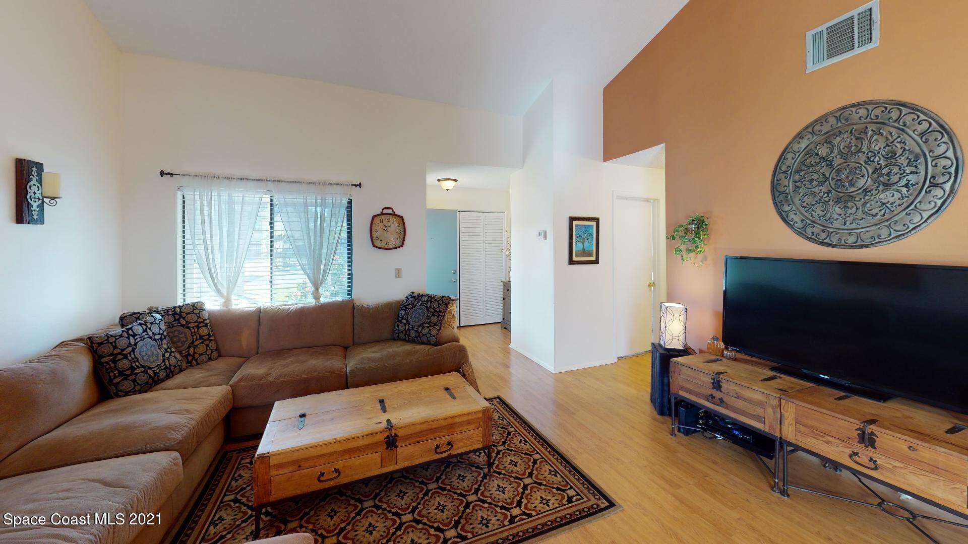 2210 Golf Isle Drive, Unit 906 Melbourne, FL 32935 - Photo 24 of 74 a living room with furniture and a flat screen tv