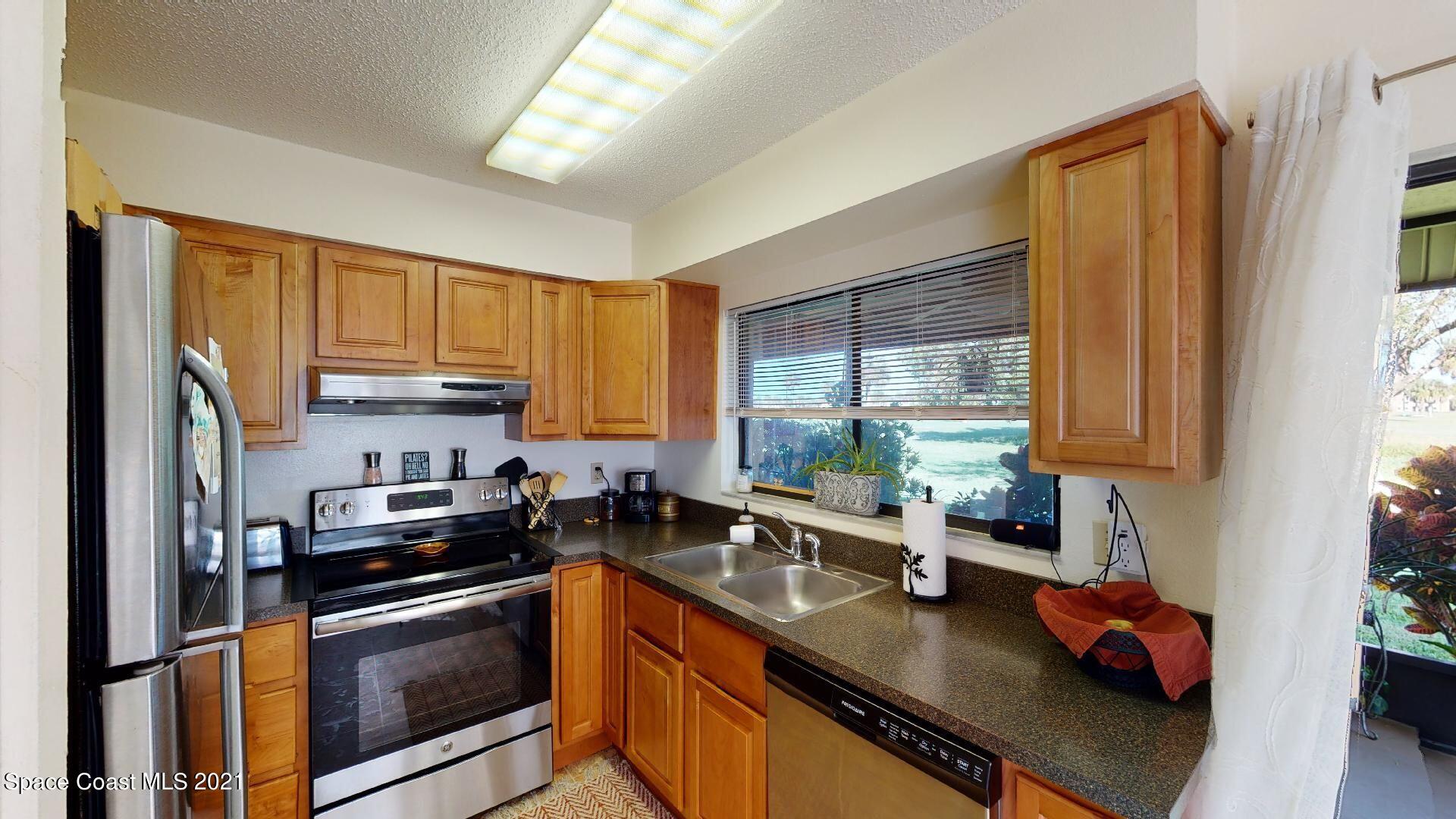 2210 Golf Isle Drive, Unit 906 Melbourne, FL 32935 - Photo 35 of 74 a kitchen with stainless steel appliances granite countertop a sink a stove and a refrigerator