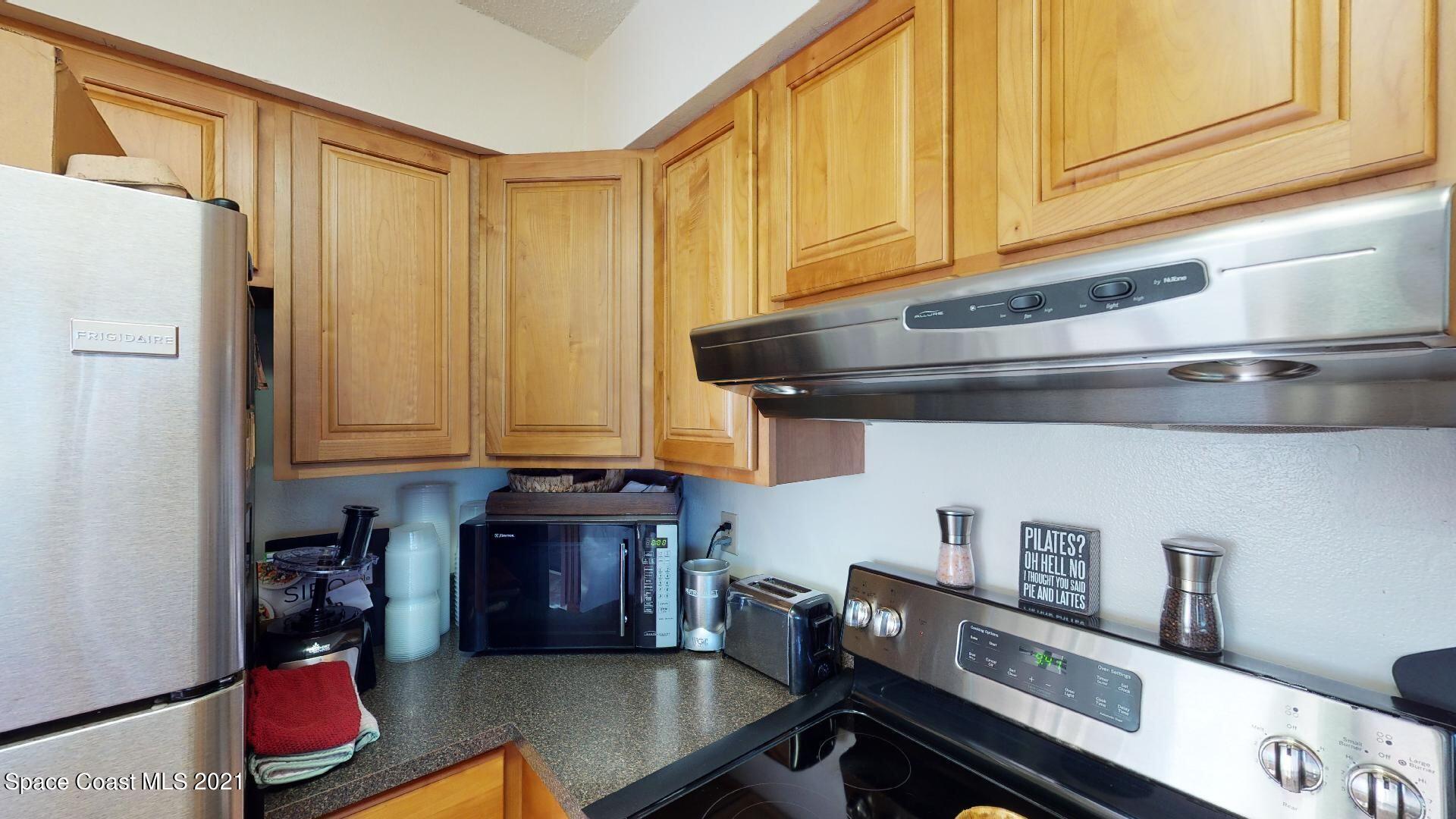2210 Golf Isle Drive, Unit 906 Melbourne, FL 32935 - Photo 37 of 74 a kitchen with stainless steel appliances granite countertop a refrigerator a stove and a sink