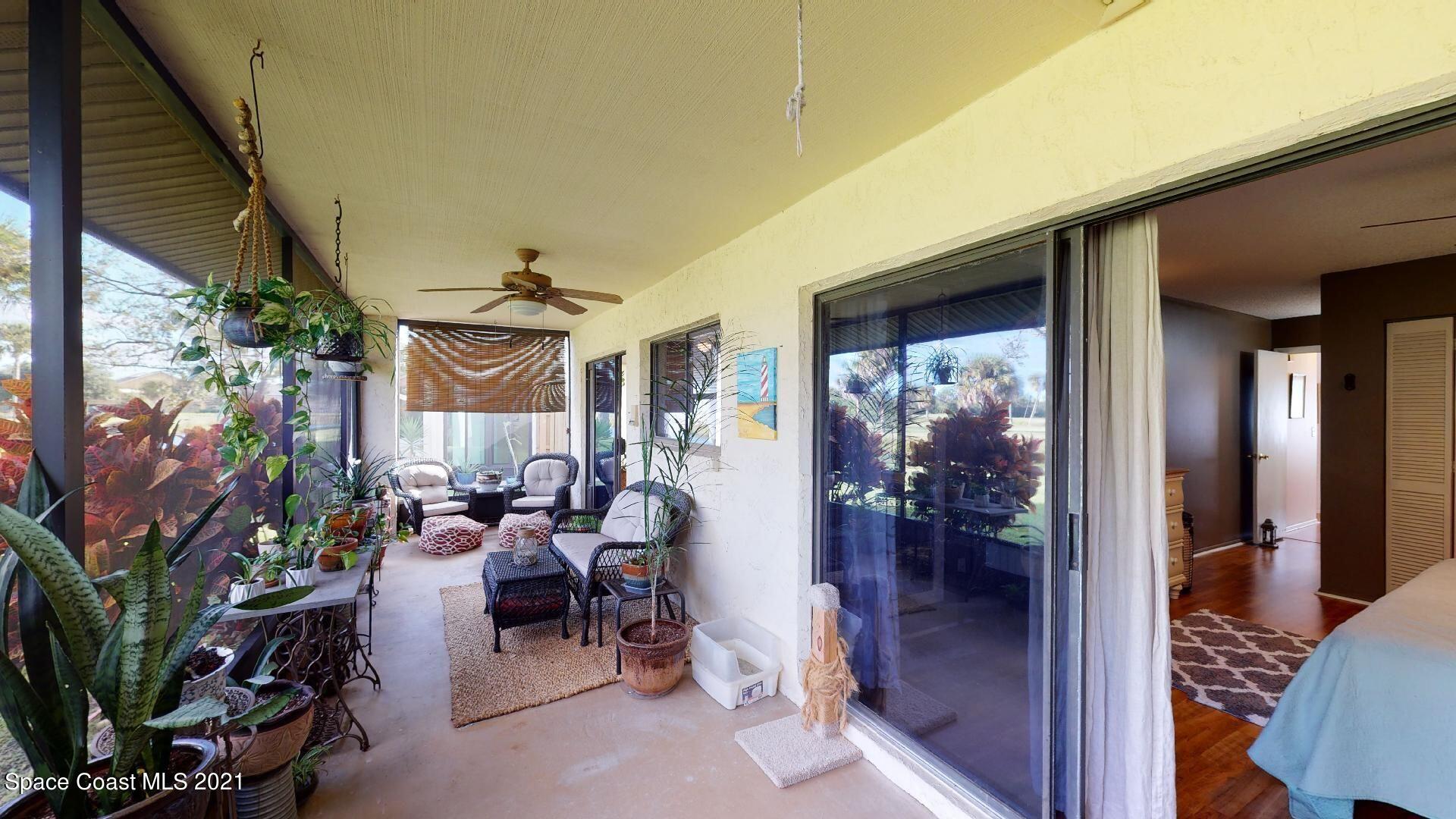 2210 Golf Isle Drive, Unit 906 Melbourne, FL 32935 - Photo 44 of 74 a view of a porch with chairs and potted plants
