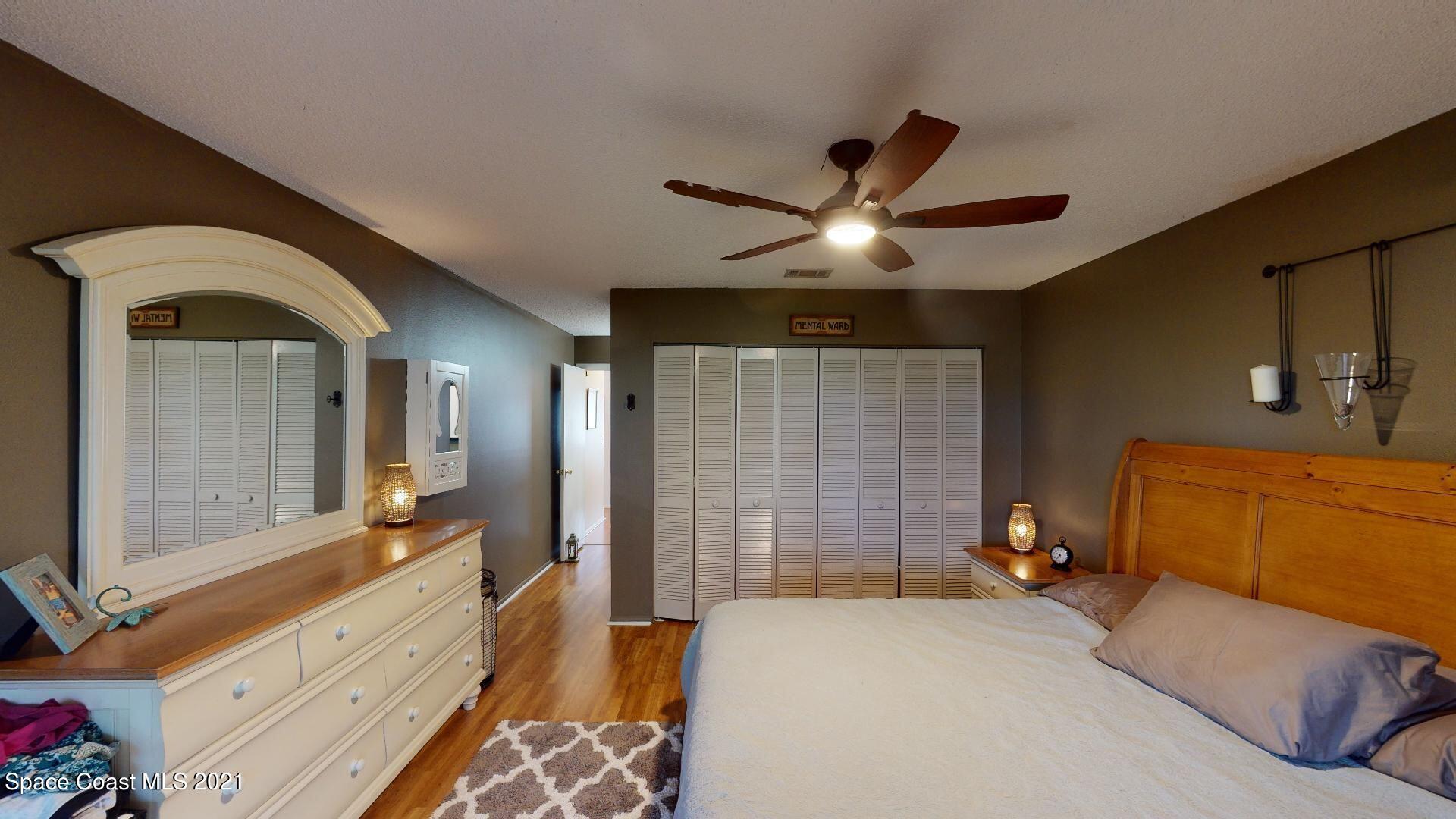 2210 Golf Isle Drive, Unit 906 Melbourne, FL 32935 - Photo 48 of 74 a bedroom with a bed and a chandelier