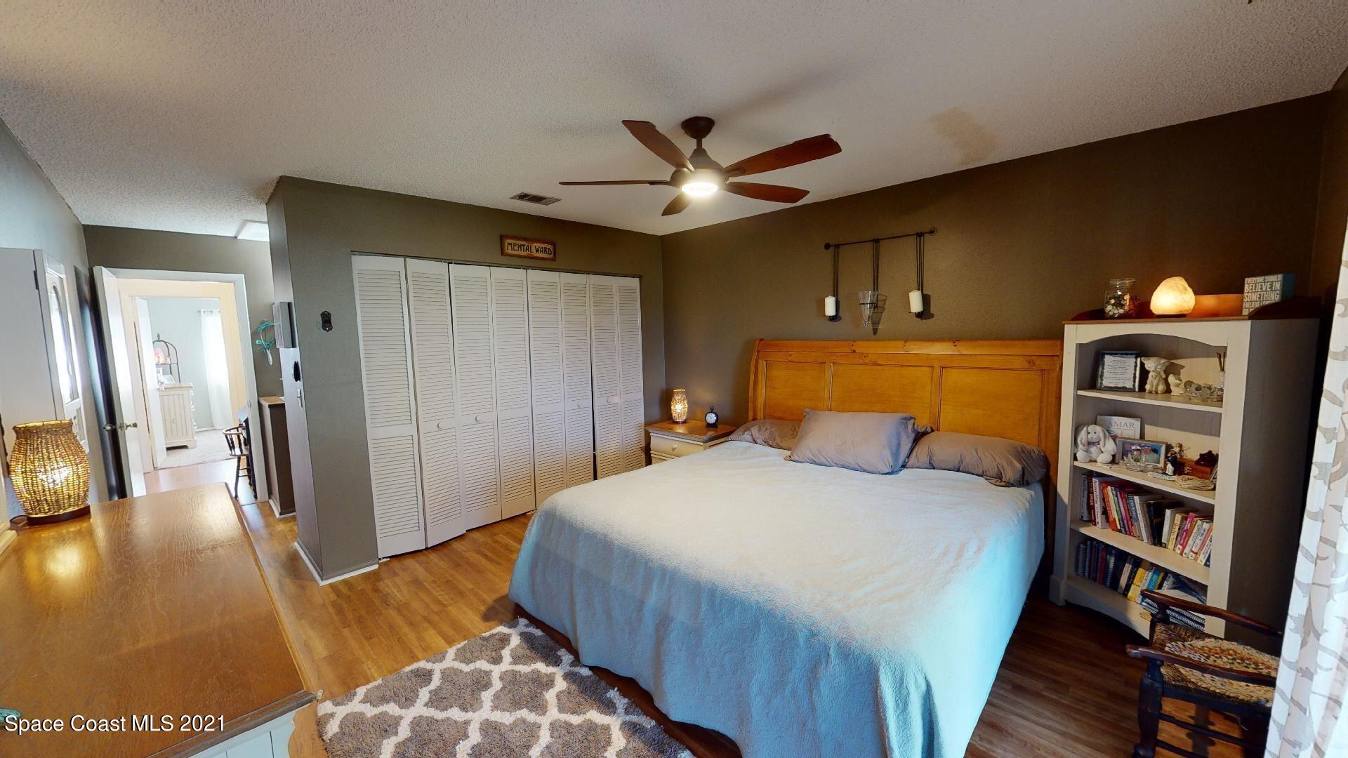 2210 Golf Isle Drive, Unit 906 Melbourne, FL 32935 - Photo 49 of 74 a bedroom with a bed and a book shelf
