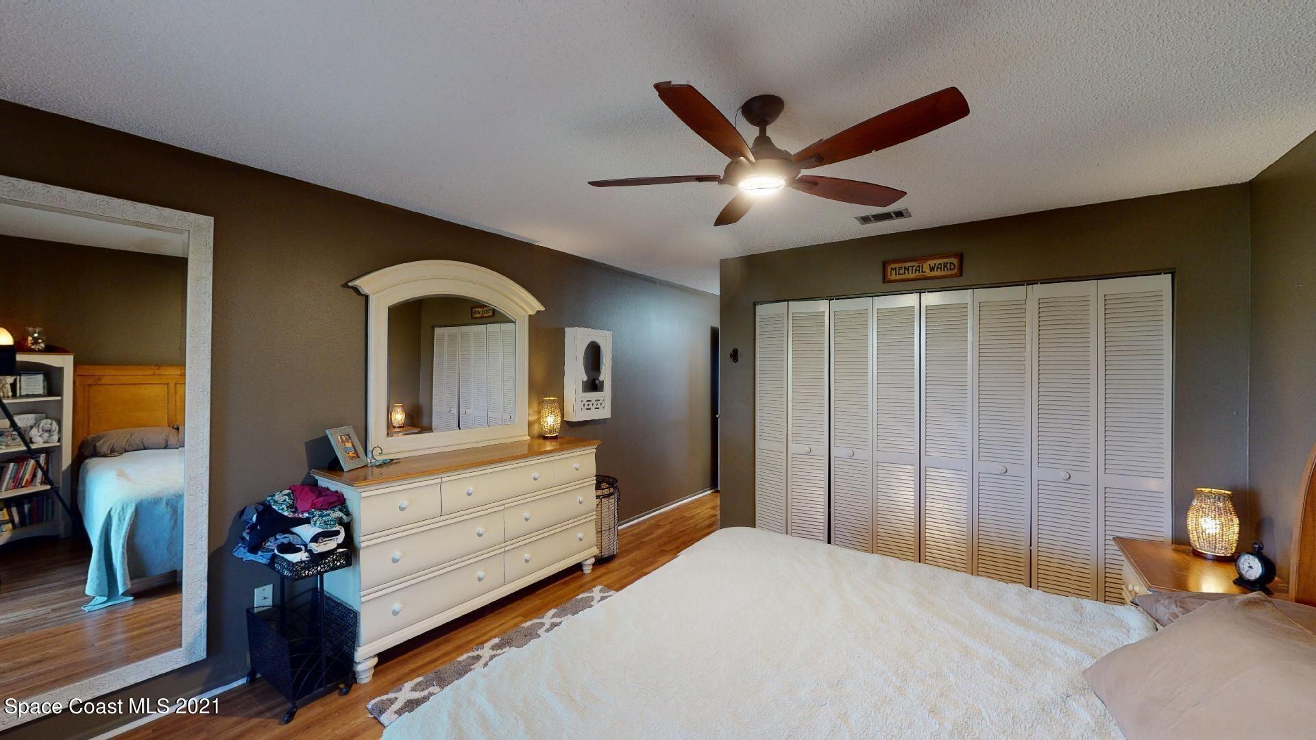 2210 Golf Isle Drive, Unit 906 Melbourne, FL 32935 - Photo 50 of 74 a bedroom with a bed and a chandelier