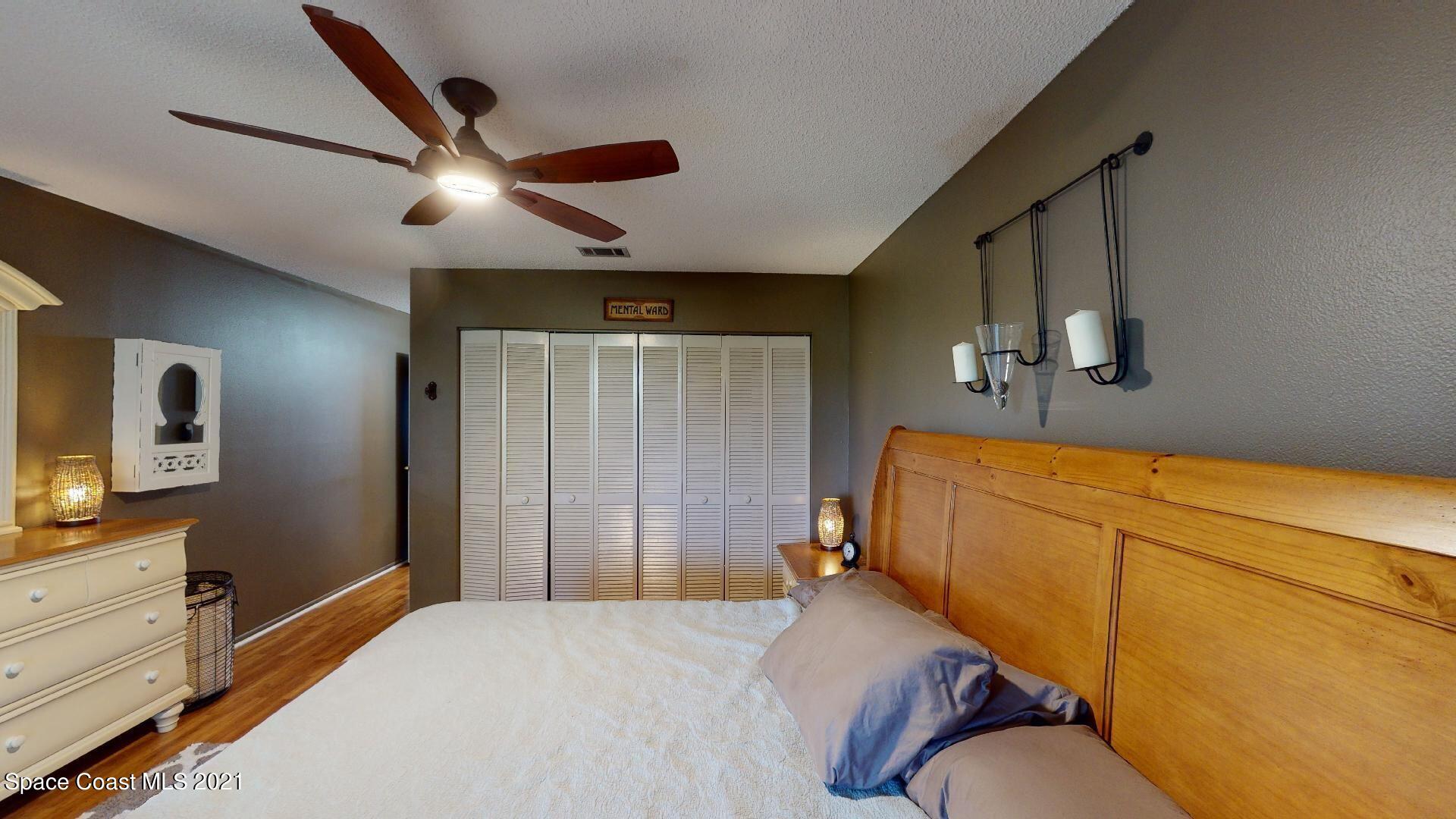 2210 Golf Isle Drive, Unit 906 Melbourne, FL 32935 - Photo 51 of 74 a bedroom with a bed and wooden floor
