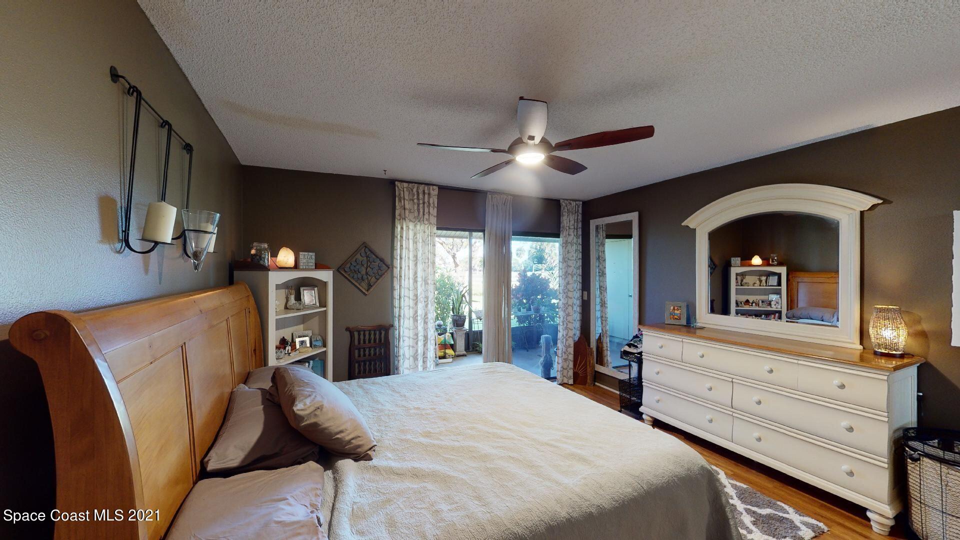 2210 Golf Isle Drive, Unit 906 Melbourne, FL 32935 - Photo 52 of 74 a bedroom with furniture and a flat screen tv