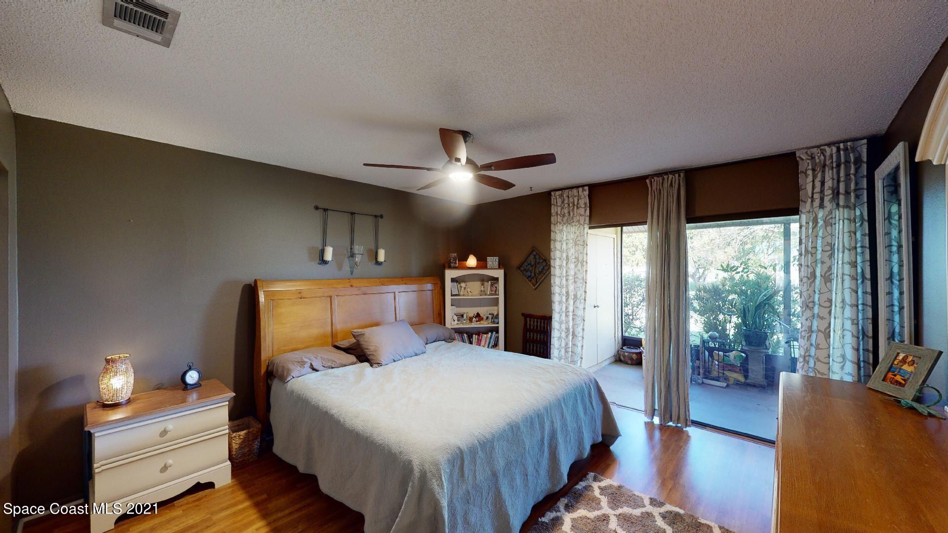 2210 Golf Isle Drive, Unit 906 Melbourne, FL 32935 - Photo 54 of 74 a bed room with a bed and a chandelier