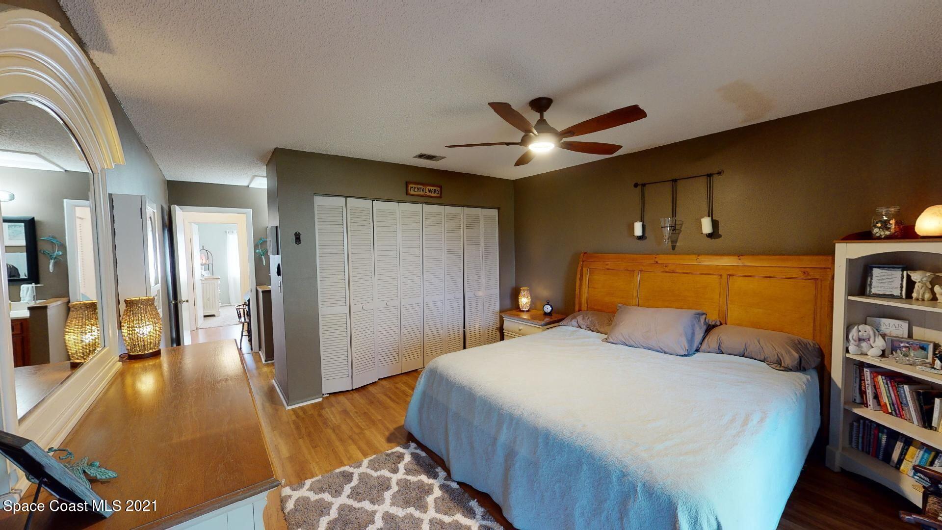 2210 Golf Isle Drive, Unit 906 Melbourne, FL 32935 - Photo 55 of 74 a bedroom with a bed and a book shelf