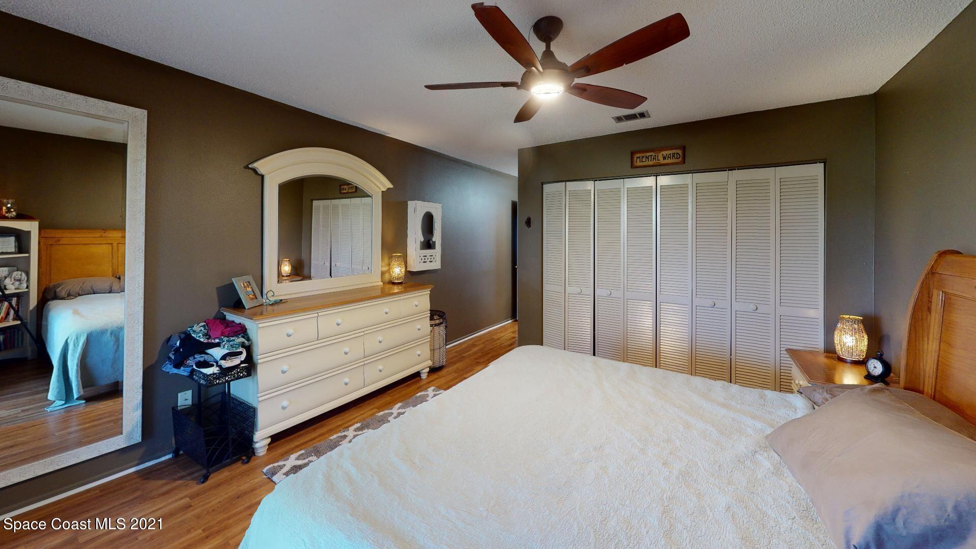 2210 Golf Isle Drive, Unit 906 Melbourne, FL 32935 - Photo 57 of 74 a bedroom with a bed and a chandelier