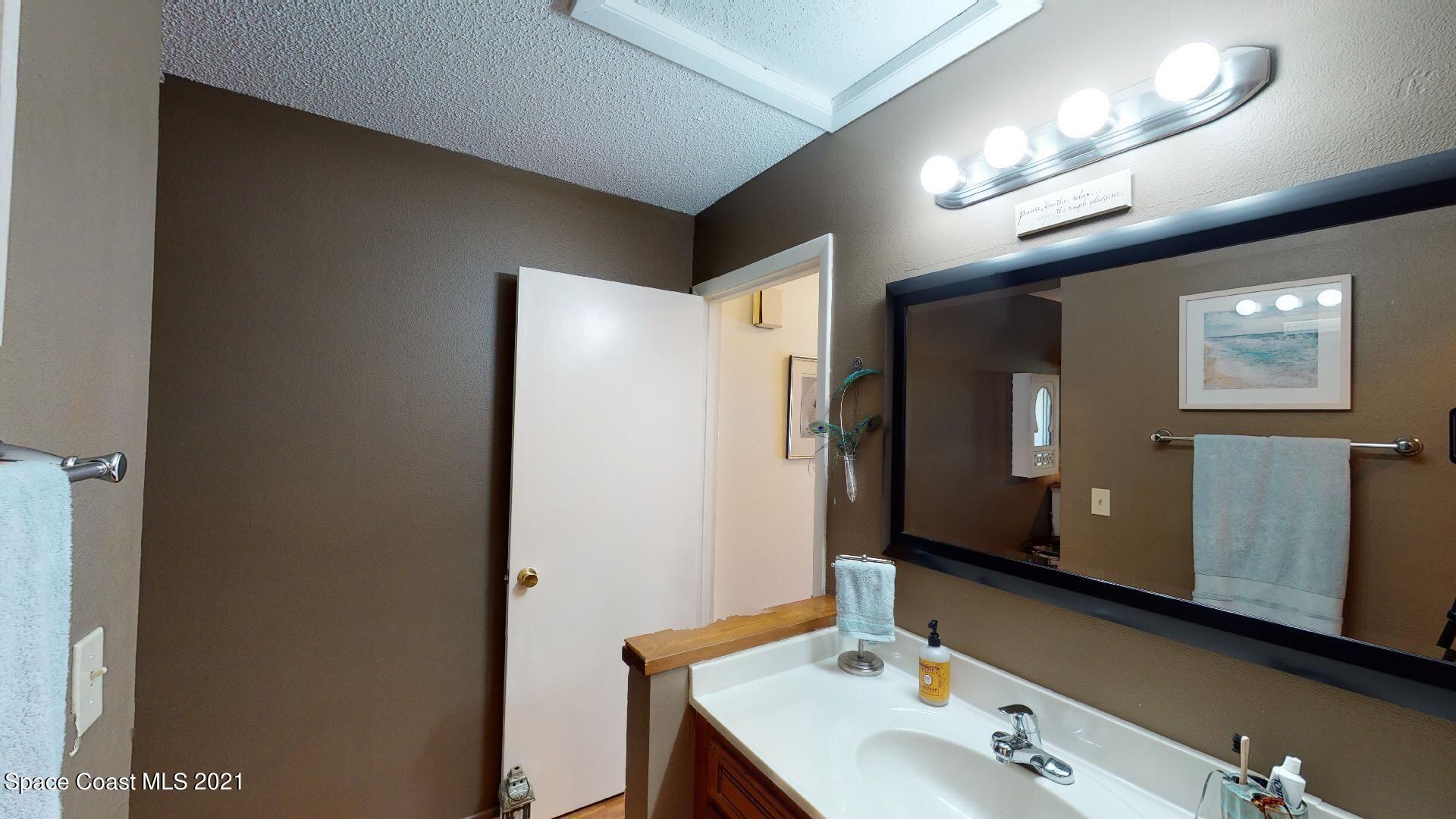 2210 Golf Isle Drive, Unit 906 Melbourne, FL 32935 - Photo 59 of 74 a bathroom with a sink and a mirror