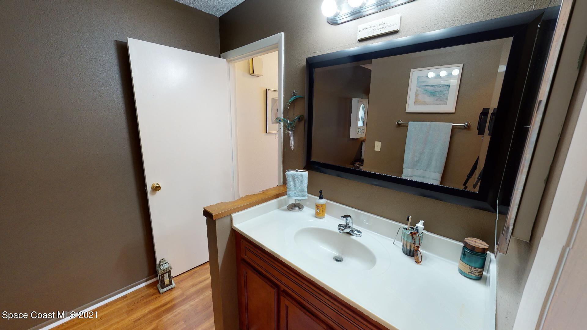 2210 Golf Isle Drive, Unit 906 Melbourne, FL 32935 - Photo 60 of 74 a bathroom with a sink and mirror