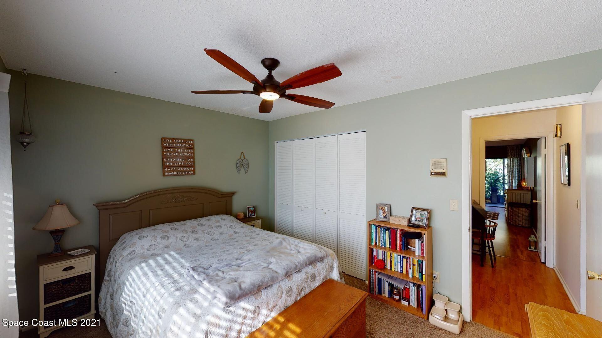 2210 Golf Isle Drive, Unit 906 Melbourne, FL 32935 - Photo 64 of 74 a bedroom with a bed and a book shelf