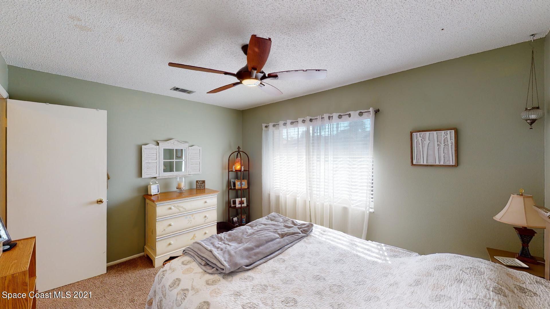 2210 Golf Isle Drive, Unit 906 Melbourne, FL 32935 - Photo 66 of 74 a bedroom with a bed and a chandelier