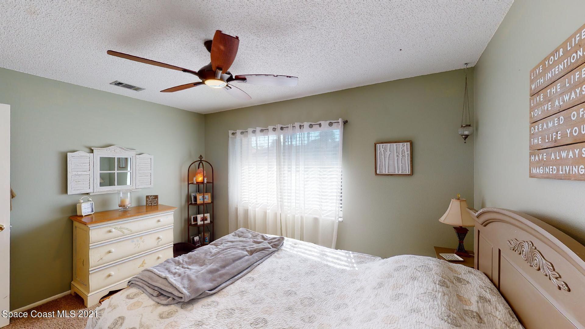 2210 Golf Isle Drive, Unit 906 Melbourne, FL 32935 - Photo 67 of 74 a bedroom with a bed and a chandelier