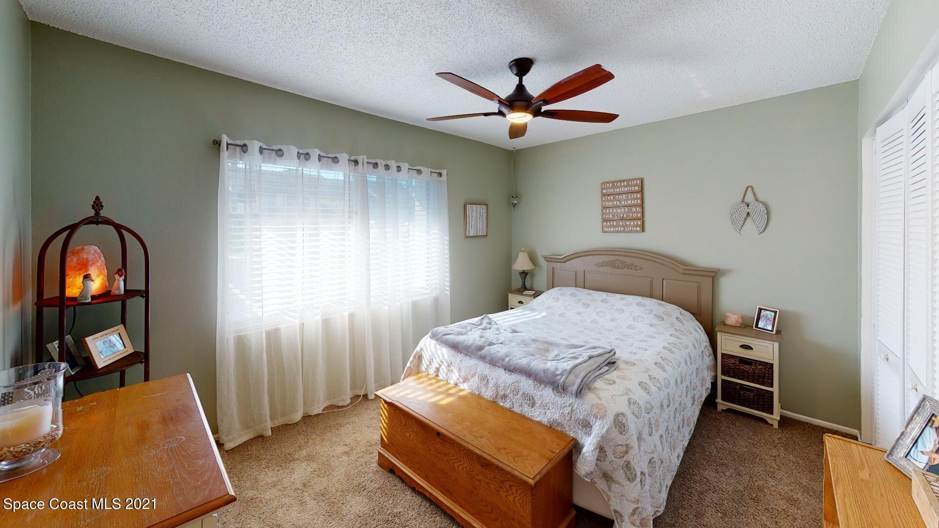 2210 Golf Isle Drive, Unit 906 Melbourne, FL 32935 - Photo 68 of 74 a bedroom with a bed and a mirror on the dresser
