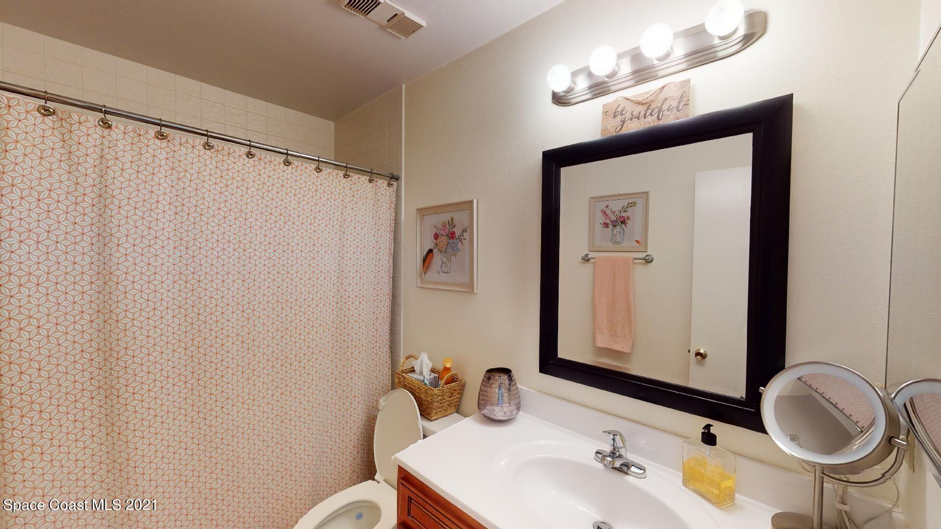 2210 Golf Isle Drive, Unit 906 Melbourne, FL 32935 - Photo 69 of 74 a bathroom with a sink vanity mirror and toilet