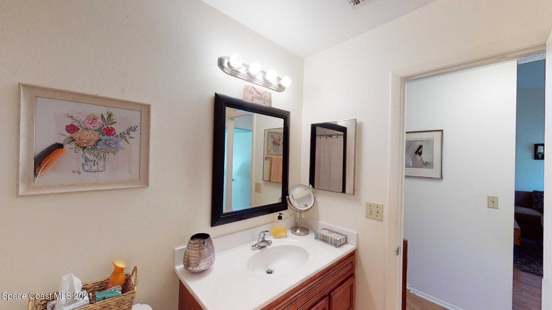 2210 Golf Isle Drive, Unit 906 Melbourne, FL 32935 - Photo 70 of 74 a bathroom with double vanity sinks and a mirror