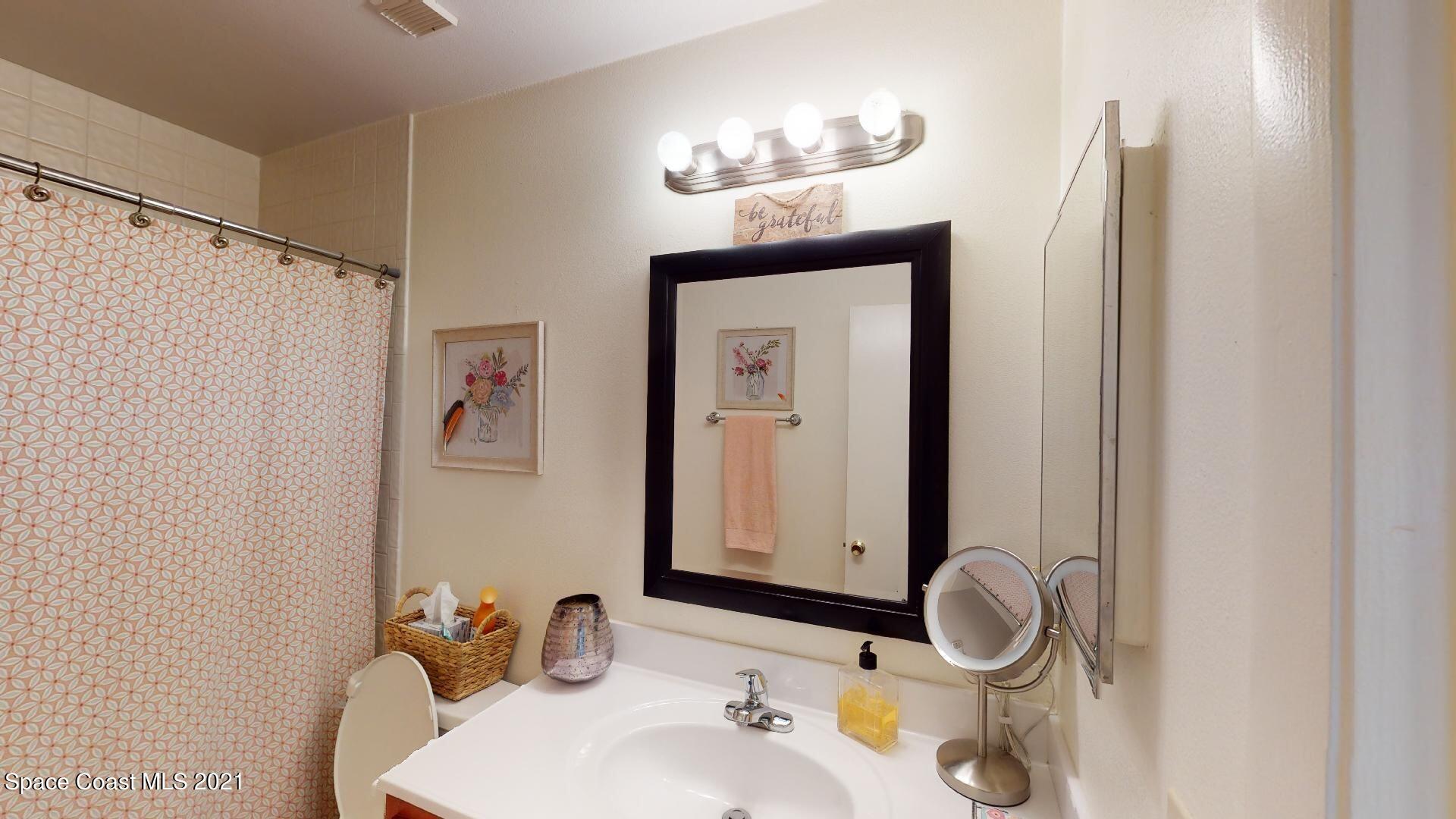 2210 Golf Isle Drive, Unit 906 Melbourne, FL 32935 - Photo 71 of 74 a bathroom with a sink and a mirror