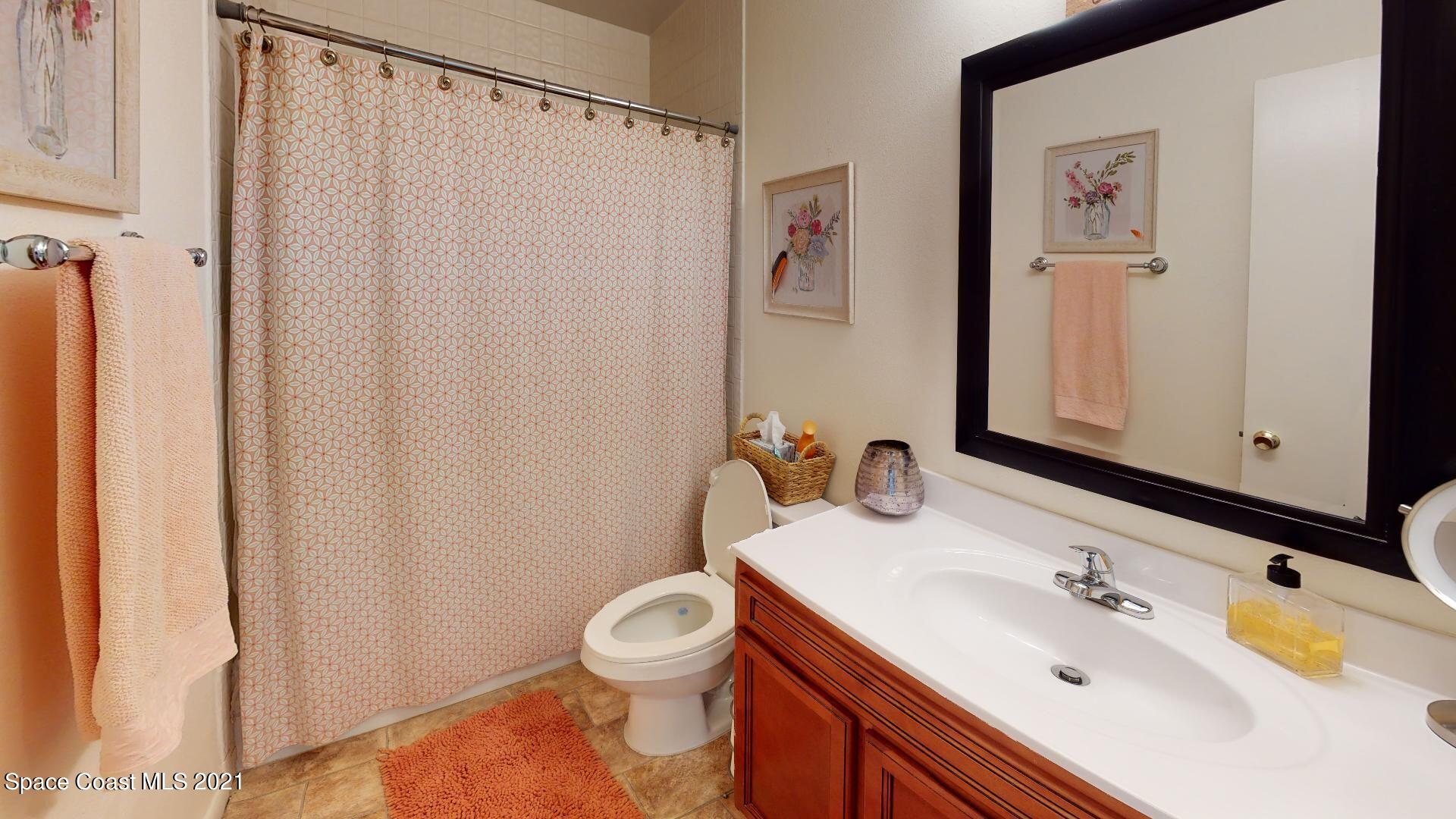 2210 Golf Isle Drive, Unit 906 Melbourne, FL 32935 - Photo 72 of 74 a bathroom with a sink a toilet and shower curtain
