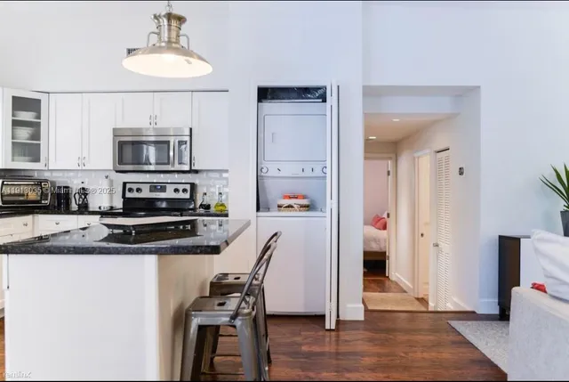 a kitchen with stainless steel appliances granite countertop a stove a microwave a sink and cabinets