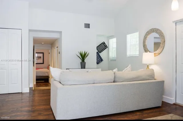 a living room with furniture and a wooden floor