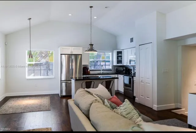 a kitchen with stainless steel appliances granite countertop a refrigerator a stove a sink and a refrigerator