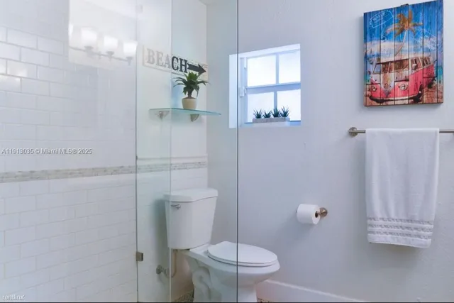 a bathroom with a toilet and a shower