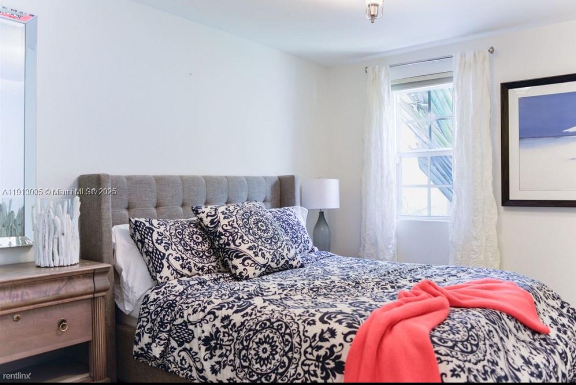 7611 Abbott Avenue, Unit R Miami Beach, FL 33141 - Photo 8 of 10 a bedroom with a bed and a window