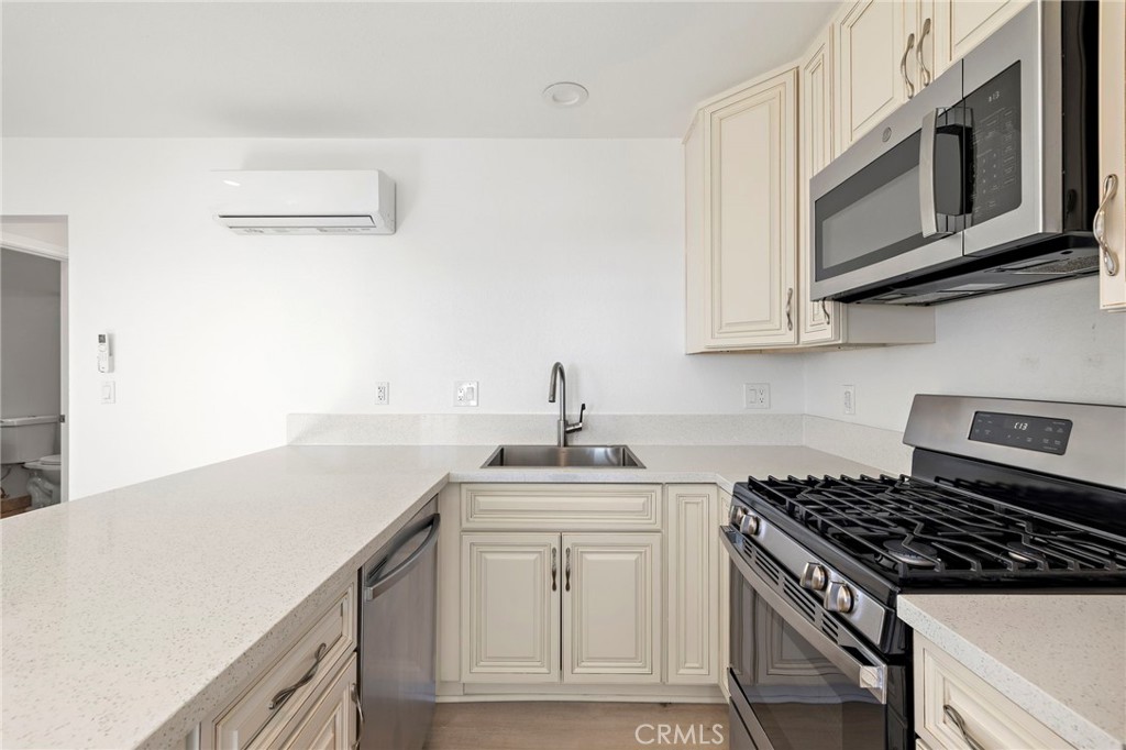 33771 Copper Lantern Street, Unit B Dana Point, CA 92629 - Photo 6 of 14 a kitchen with stainless steel appliances a sink stove and cabinets