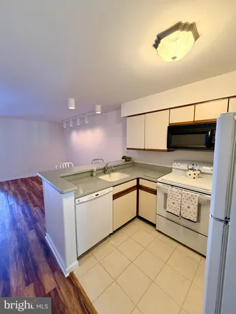 a kitchen with a sink cabinets and wooden floor