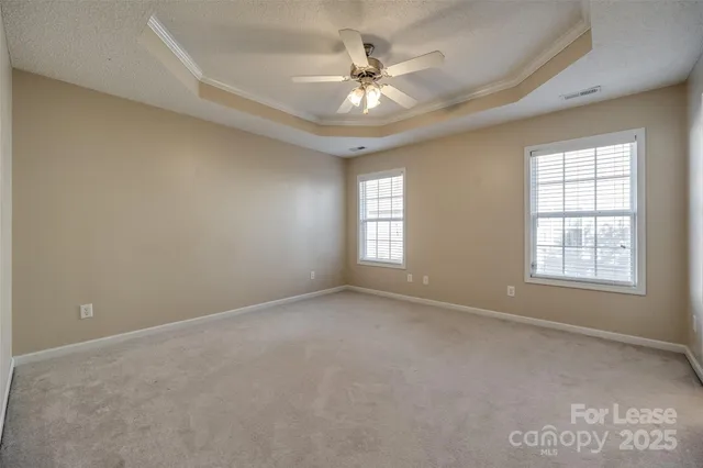 an empty room with windows and ceiling fan