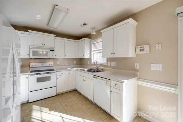 a kitchen with cabinets appliances a sink and a counter top space