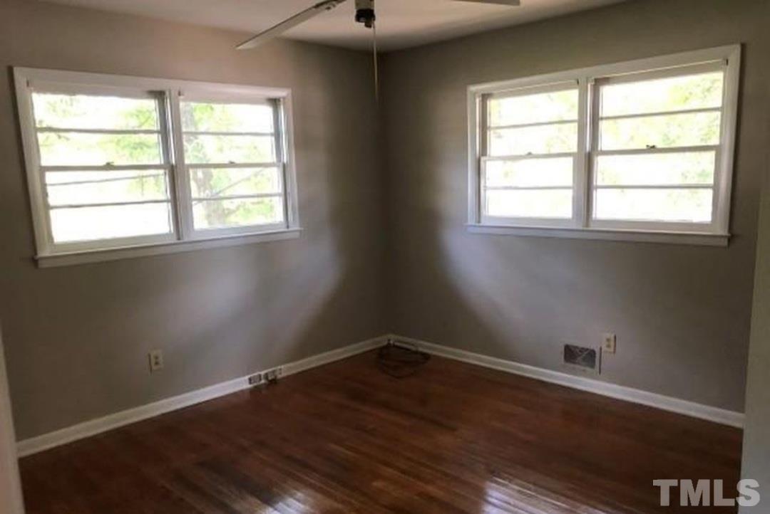 3218 Poole Road Raleigh, NC 27610 - Photo 6 of 6 an empty room with wooden floor and windows