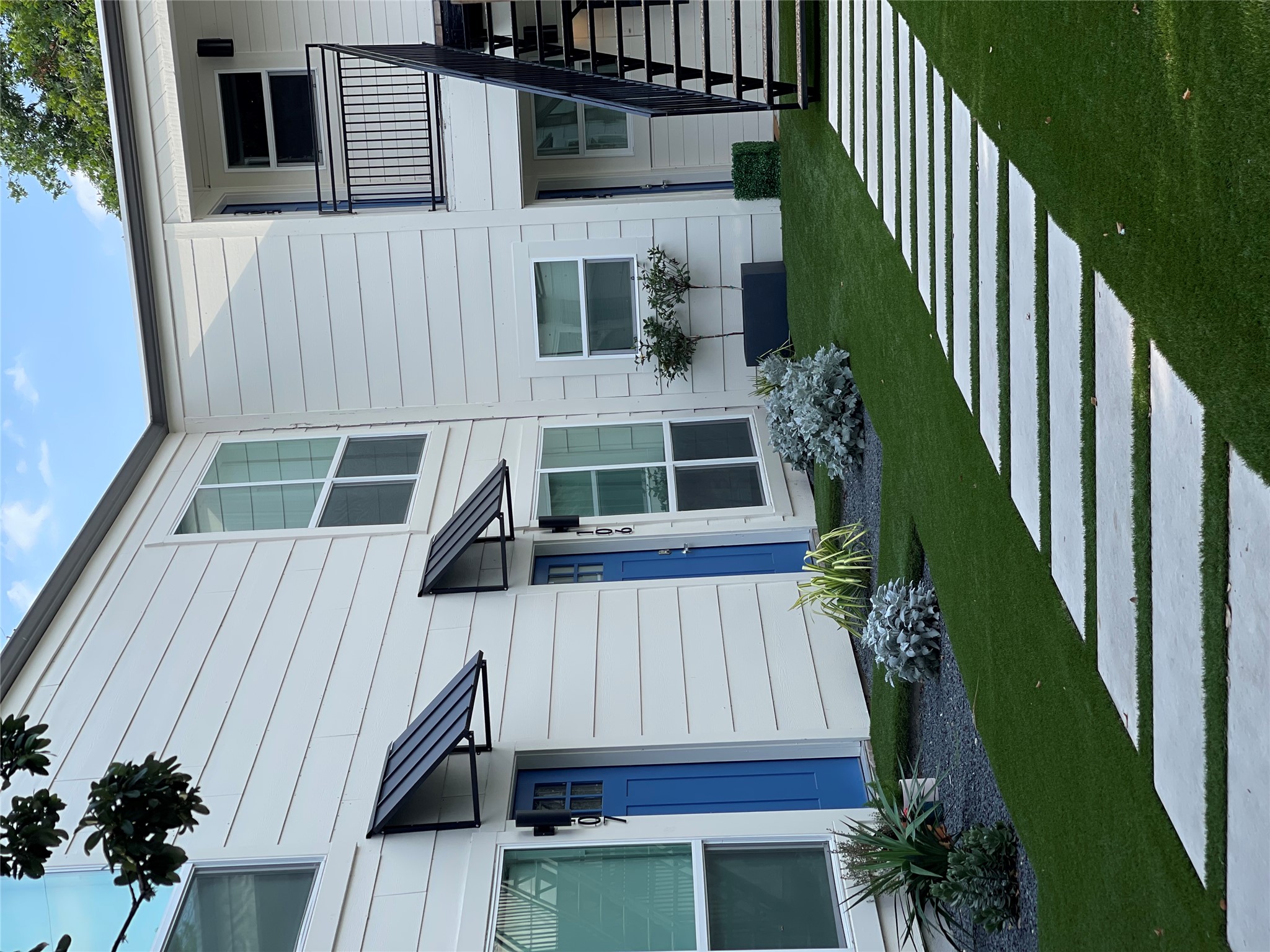 1714 Enfield Road, Unit 102 Austin, TX 78703 - Photo 14 of 15 Clean lines define this multi-unit dwelling with a neatly manicured lawn and geometric paver path.