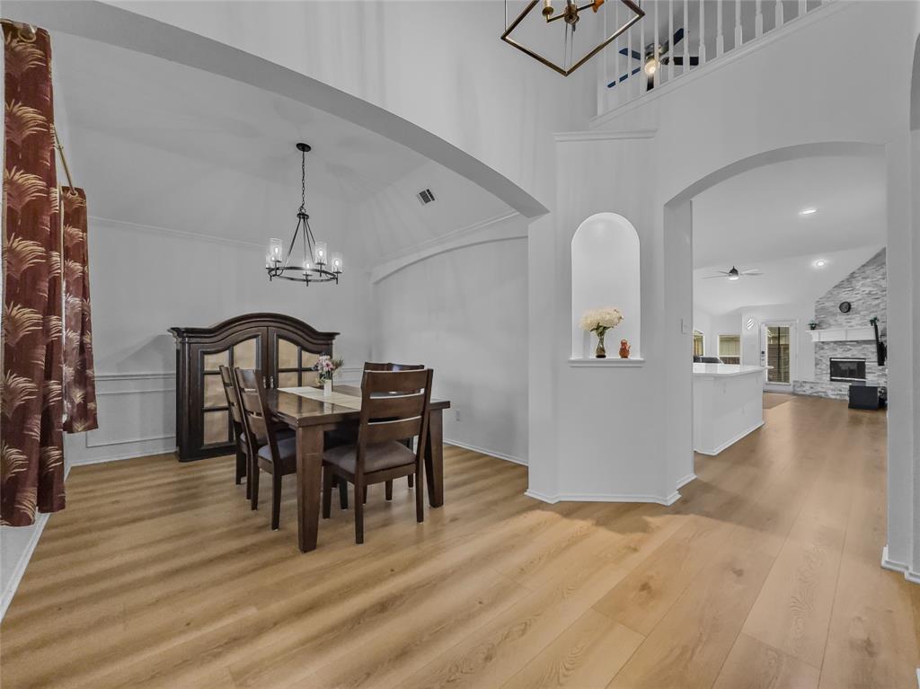 3008 Devlin Ridge Drive Plano, TX 75025 - Photo 24 of 24 Dining area featuring high vaulted ceilings, light wood-finish flooring, wainscoting, and a contemporary chandelier