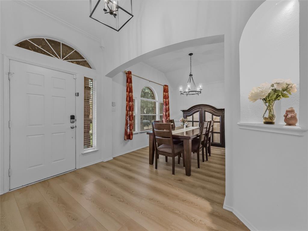 3008 Devlin Ridge Drive Plano, TX 75025 - Photo 3 of 24 Entryway featuring wood-finish flooring, a white paneled door with an arched transom window, and a sidelight with blinds