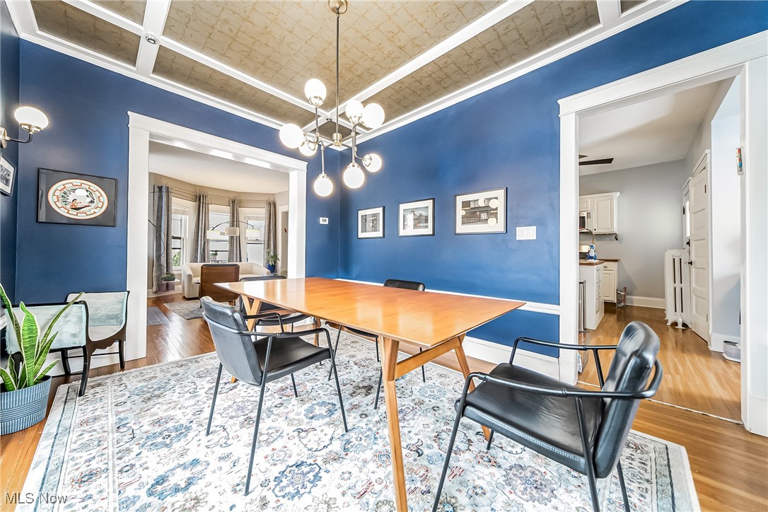3733 Montevista Road Cleveland, OH 44121 - Photo 6 of 35 Dining room with radiator heating unit, wood-type flooring, ceiling fan with notable chandelier, and ornamental molding