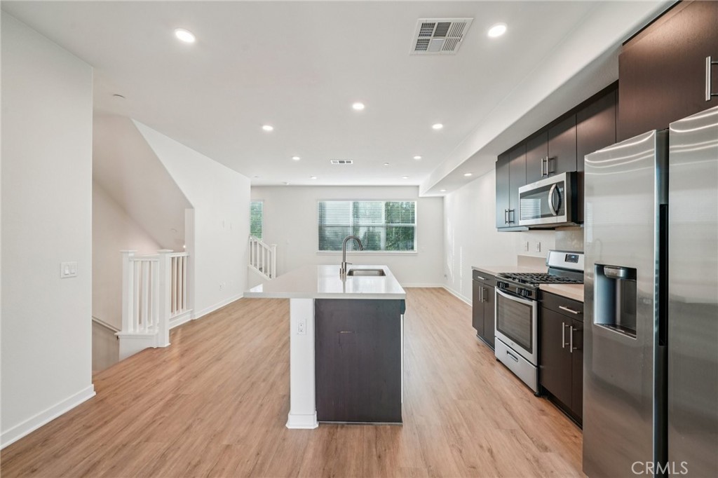 9422 Shade Place Rancho Cucamonga, CA 91730 - Photo 13 of 72 a kitchen with stainless steel appliances granite countertop a refrigerator a stove top oven a sink dishwasher and wooden floor