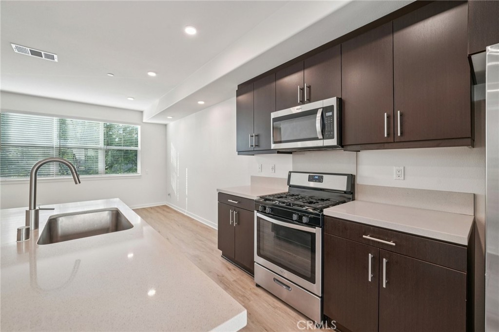 9422 Shade Place Rancho Cucamonga, CA 91730 - Photo 15 of 72 a kitchen that has a sink and a stove