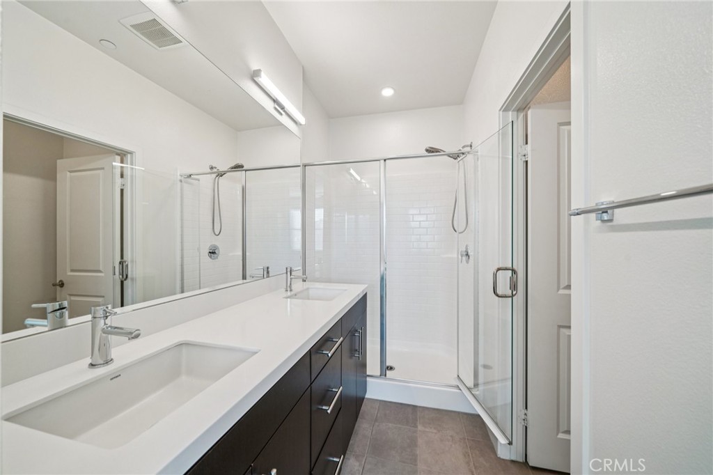 9422 Shade Place Rancho Cucamonga, CA 91730 - Photo 32 of 72 a bathroom with a double vanity sink mirror and shower