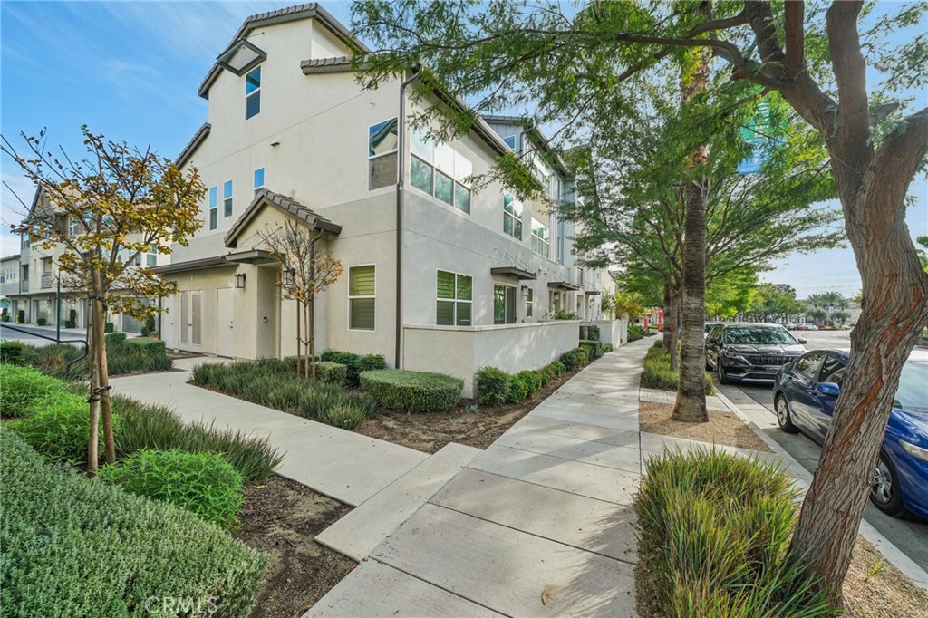 9422 Shade Place Rancho Cucamonga, CA 91730 - Photo 50 of 72 a view of a white house with a large tree and couches